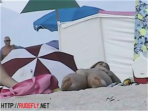 Beach bombshells suspend out nude below the sun
